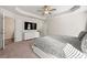 Spacious main bedroom featuring tray ceilings, a ceiling fan, a large TV, and a walk-in closet at 6372 Rosetta Sw Dr, Atlanta, GA 30331