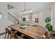 Bright dining room with modern light fixture and open floor plan leading to kitchen and staircase at 2062 Cortland Rd, Milton, GA 30009