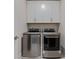 Functional laundry room with modern washer and dryer beneath white cabinets at 2062 Cortland Rd, Milton, GA 30009