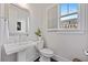 The powder room features a pedestal sink, modern fixtures, and a window, creating a bright and functional space at 2062 Cortland Rd, Milton, GA 30009