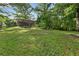 View of the spacious backyard featuring lush green lawn, mature trees, and a deck perfect for outdoor activities at 2337 Elmwood Se Cir, Atlanta, GA 30339