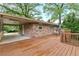 Brick home featuring a large wood deck with a carport, combining outdoor living with practical covered parking at 2337 Elmwood Se Cir, Atlanta, GA 30339