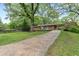 A home with green lawn and mature trees, featuring a covered carport at 2337 Elmwood Se Cir, Atlanta, GA 30339