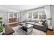 Bright living room with a gray sectional sofa, open to the dining area, with large windows at 2337 Elmwood Se Cir, Atlanta, GA 30339