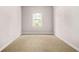 This bedroom has neutral walls and carpet, and a window overlooking green space at 2529 Ryne St, Atlanta, GA 30318
