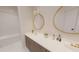 Bright bathroom with double vanity, gold fixtures, round mirrors, and white tile flooring creating an elegant spa-like retreat at 324 Treble Way, Alpharetta, GA 30009