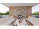 Inviting outdoor patio featuring a stone fireplace, comfortable seating, and serene natural surroundings at 324 Treble Way, Alpharetta, GA 30009