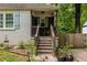 Inviting front porch with a rocking chair, surrounded by lush greenery and potted plants at 1866 Tiger Flowers Nw Dr, Atlanta, GA 30314