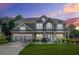 Beautiful twilight view of a two-story home with manicured lawn, stone accents and gray siding at 2625 Blackstock Dr, Cumming, GA 30041