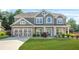 Charming two-story home with gray siding, stone accents, and a well-manicured lawn at 2625 Blackstock Dr, Cumming, GA 30041