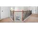 An upstairs hallway featuring wood and iron railings, with white trim, baseboards, and carpet at 2625 Blackstock Dr, Cumming, GA 30041