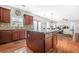 A spacious kitchen with an island, wood cabinets, stone countertops, and is open to the living room at 2625 Blackstock Dr, Cumming, GA 30041