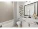 Well-lit bathroom with a decorative tile wall, a large black framed mirror, and a shower-tub combination at 326 Treble Way, Alpharetta, GA 30009
