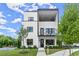 Modern two-story home featuring white brick, black trim, a covered balcony and a well-manicured lawn at 326 Treble Way, Alpharetta, GA 30009