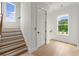 Bright hallway with wooden stairs and hardwood floors, illuminated by natural light from a window at 326 Treble Way, Alpharetta, GA 30009