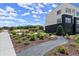 Landscaped community walking path with lush greenery, flower beds, and comfortable seating areas for relaxation at 326 Treble Way, Alpharetta, GA 30009