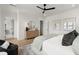 Bright main bedroom boasts a ceiling fan, ensuite bathroom, and warm hardwood flooring at 326 Treble Way, Alpharetta, GA 30009