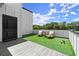 Relaxing rooftop terrace with artificial grass, outdoor seating, and open sky views provides a serene outdoor escape at 326 Treble Way, Alpharetta, GA 30009