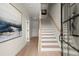 Inviting entryway features light hardwood floors, white stairs, and a striking modern art piece at 435 Mezzo Ln # 86, Alpharetta, GA 30009