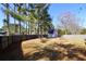 Large backyard with a tall wooden fence and a wooden shed nestled among towering trees at 701 Monticello Ln, Mcdonough, GA 30253