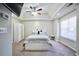 Bright bedroom with tray ceilings and a ceiling fan, a large window, and white furnishings at 701 Monticello Ln, Mcdonough, GA 30253