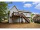 Backyard view of two-story home with deck, stairway, and light gray siding at 7832 Cambridge Dr, Douglasville, GA 30134