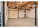 Unfinished basement with concrete floor, two garage doors, and exposed ceiling at 7832 Cambridge Dr, Douglasville, GA 30134