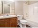 Well-lit bathroom with a wooden vanity, toilet, shower-tub combination, and modern fixtures at 7832 Cambridge Dr, Douglasville, GA 30134