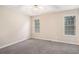 Bedroom with natural light from two windows, carpeted floors, and a modern ceiling fan at 7832 Cambridge Dr, Douglasville, GA 30134