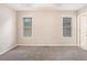 Bright bedroom featuring carpeted floors and two windows offering ample natural light at 7832 Cambridge Dr, Douglasville, GA 30134