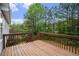 View of wooden deck overlooking backyard with lush trees under a blue sky at 7832 Cambridge Dr, Douglasville, GA 30134