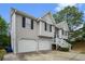 View of the side of the home with gray siding and two-car garage with a long driveway at 7832 Cambridge Dr, Douglasville, GA 30134