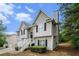 View of the side of the home showing gray siding, windows with black shutters, and landscaping at 7832 Cambridge Dr, Douglasville, GA 30134