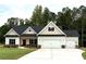 Beautifully landscaped home with a three-car garage, stone accents, and a welcoming front porch at 877 Highway 101 N, Dallas, GA 30157