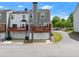 View of the back of a townhome, with a spacious back deck, garages, and well-maintained surroundings at 1237 Park Pass Way, Suwanee, GA 30024