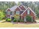 Beautiful two-story red brick home with black shutters and lush landscaping in a sought-after neighborhood at 4319 Silver Peak Pkwy, Suwanee, GA 30024