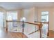 Upper hallway featuring wood floors and a white banister, connecting different areas of the house at 4319 Silver Peak Pkwy, Suwanee, GA 30024