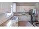 Galley kitchen features granite countertops, stainless steel appliances, and ample white cabinets for storage at 4319 Silver Peak Pkwy, Suwanee, GA 30024