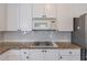 Kitchen featuring granite counters, gas range, stainless steel appliances, and white cabinets at 4319 Silver Peak Pkwy, Suwanee, GA 30024