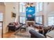 Open-concept living room with tall windows, a fireplace, wood floors, and comfortable seating arrangements at 4319 Silver Peak Pkwy, Suwanee, GA 30024
