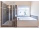 Relaxing bathroom featuring a separate shower and soaking tub with a large window at 4319 Silver Peak Pkwy, Suwanee, GA 30024