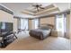 Spacious primary bedroom with a tray ceiling, plush carpet, and an entertainment center at 4319 Silver Peak Pkwy, Suwanee, GA 30024