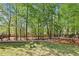 Landscaped backyard featuring a lush green lawn, mature trees, and a wooden fence for added privacy at 4360 Havenridge Pl, Cumming, GA 30041