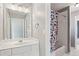 Bright bathroom with a white vanity, mirror, and a shower tub with a colorful shower curtain at 4360 Havenridge Pl, Cumming, GA 30041