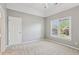 Neutral bedroom with tray ceiling, carpet, and a large window allowing natural light at 4360 Havenridge Pl, Cumming, GA 30041