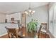 Elegant dining room featuring hardwood floors, a modern chandelier, seamlessly connected to the kitchen at 4360 Havenridge Pl, Cumming, GA 30041
