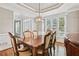 Formal dining room with decorative molding, wood table, and a modern light fixture at 4360 Havenridge Pl, Cumming, GA 30041