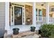 Welcoming front porch with stone accents, white columns, and a black front door with stone steps and potted plants at 4360 Havenridge Pl, Cumming, GA 30041