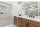Bright bathroom featuring double vanity, framed mirror, and glass walk-in shower at 654 Soul Aly # 102, Alpharetta, GA 30009