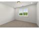 Well-lit bedroom with large window and plush carpeting at 654 Soul Aly # 102, Alpharetta, GA 30009